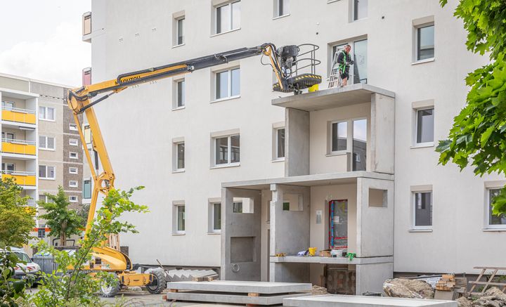 Sanierungsarbeiten in der Gartenstadt Drewitz Bausstellenfahrzeuge und große Balkonbetonteile, die an der neuen Fassade im Hetha-Thiele-Weg montiert werden.