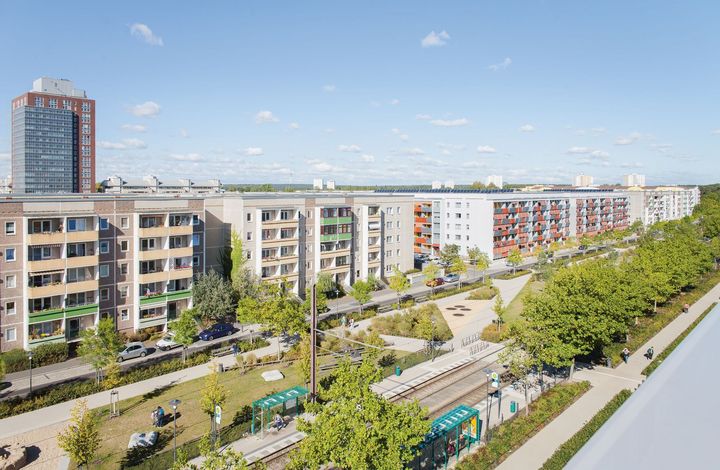 Ein grüner Park inmitten eines Wohnquartier, zwischen schmalen Straßen und Häusern.